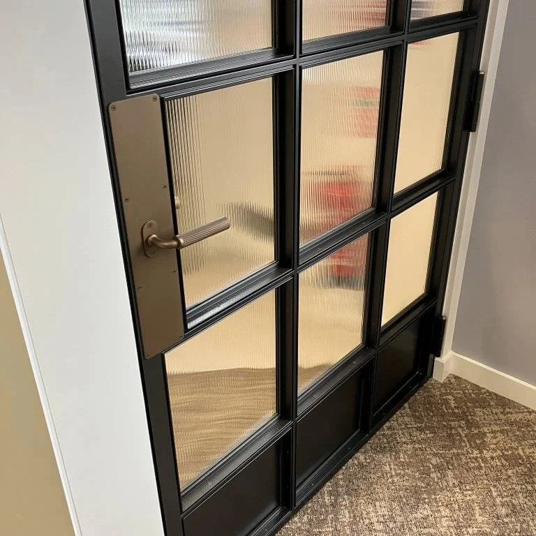 Black architectural door with coordinated powder-coated and Cerakote finishes