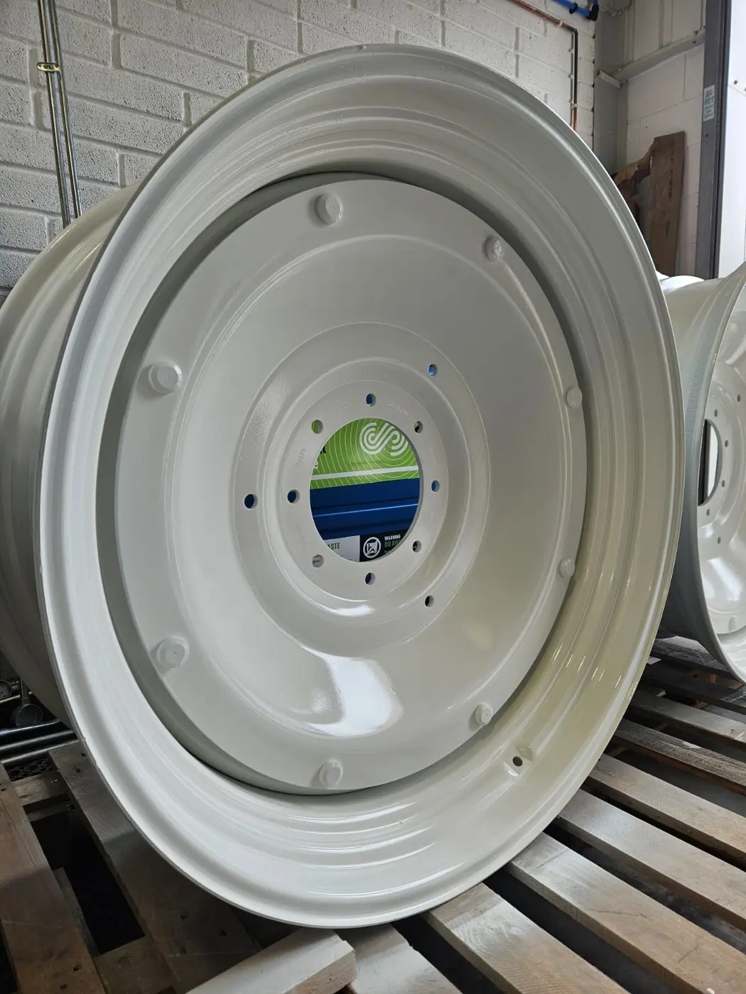 Large agricultural wheel completed with a smooth white wet-painted finish